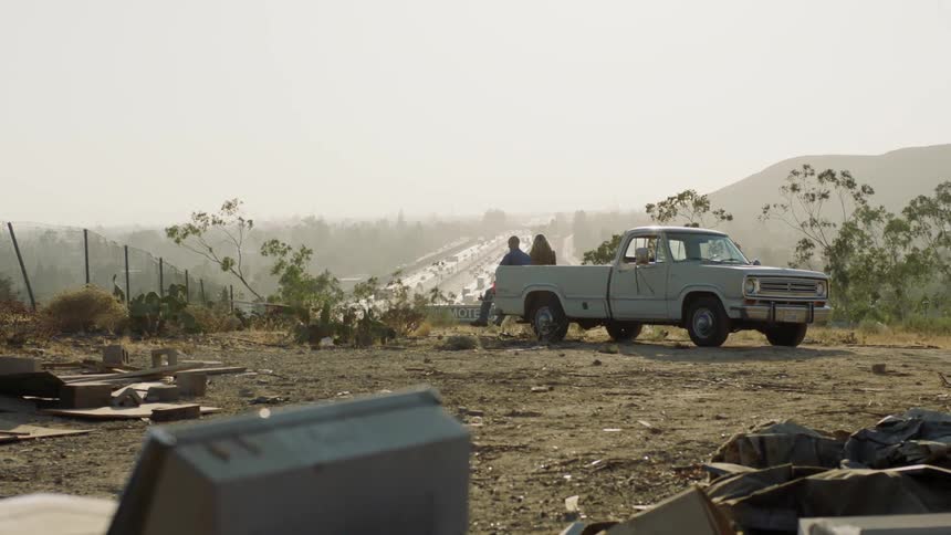 Two people sit in the pickup truck ahead