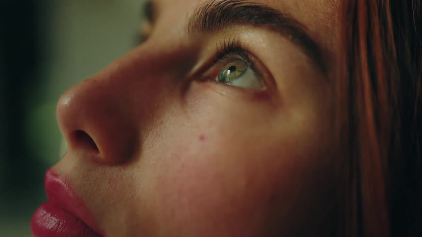 Closeup of a womans eye lit by natural light with focus on eyelashes and iris