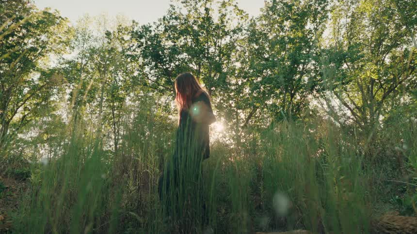 A woman walking outdoors in a forest area