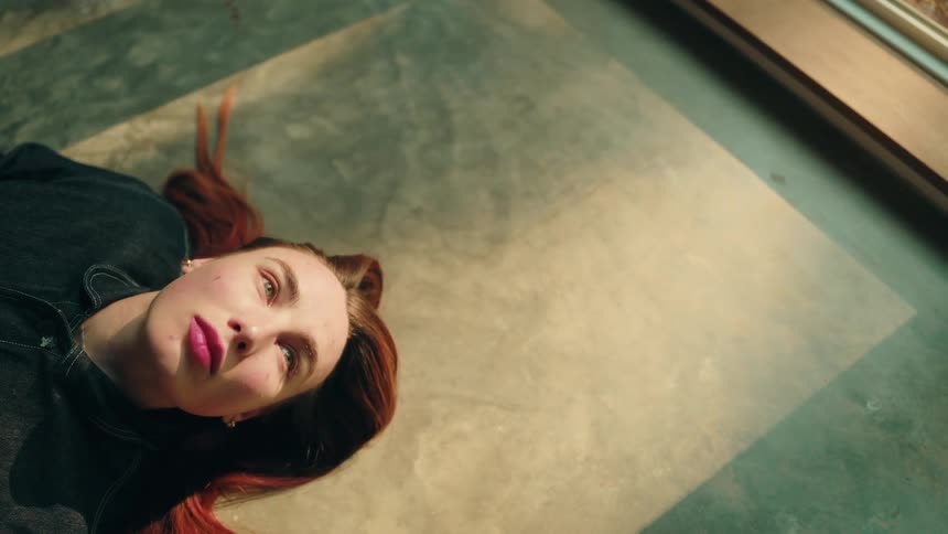 The woman blinks her eyes on the floor