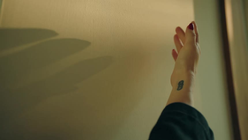 Human female touching a wall indoors during day time