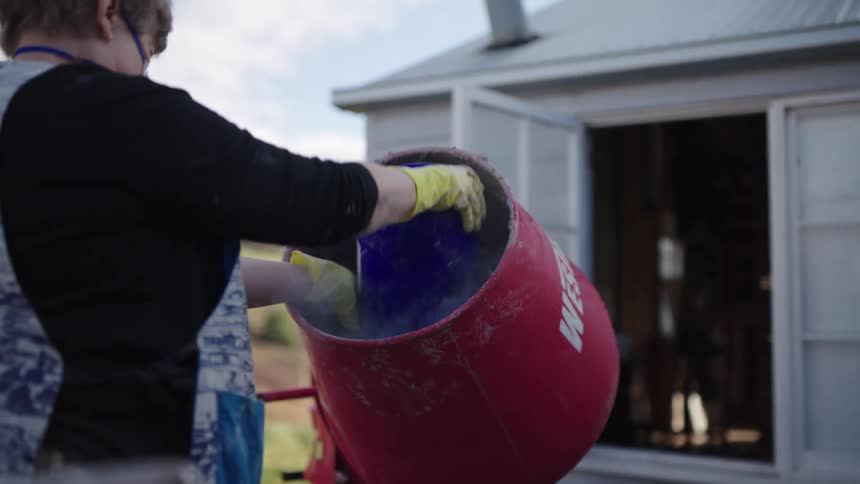 The woman pours a bucket into the container