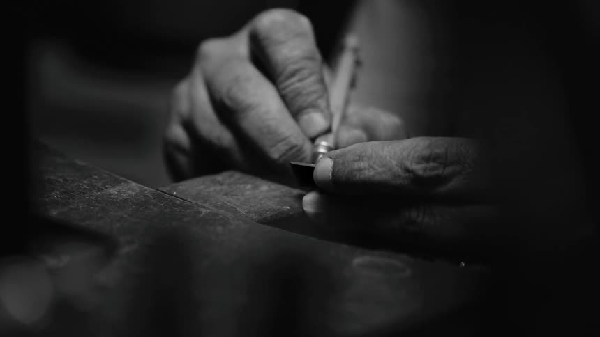 The first is a sharp diagonal line formed by the edge of the workbench or metal plate in the foreground it cuts across the frame from the lower left toward the center creating a strong sense of depth and focus on the workspace