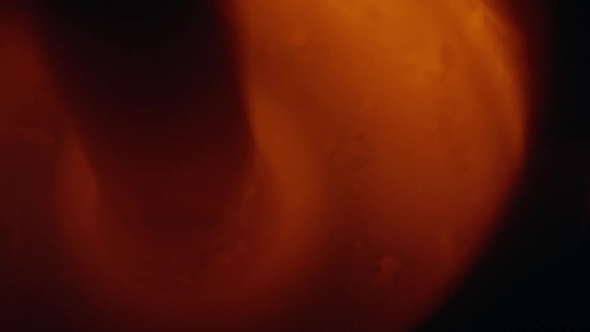 A close view of a glowing orange furnace with molten material moving inside