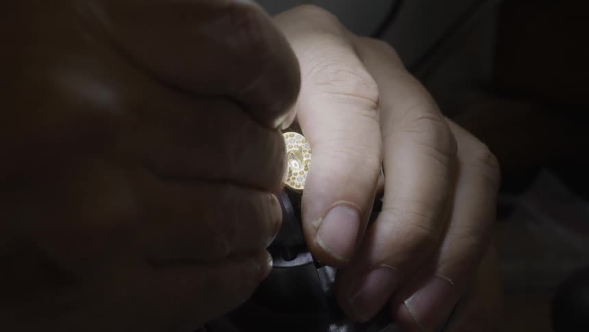 The jeweler is attaching gems to jewelry