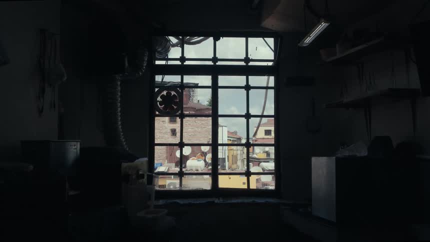 View through a window in a dark room of run down apartment buildings