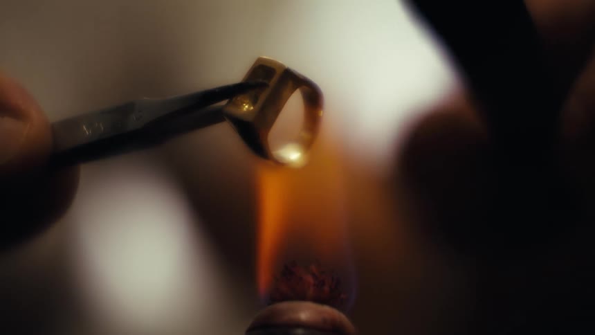 The jeweler heats a ring with a flame