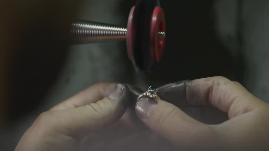 A person polishing some jewelry