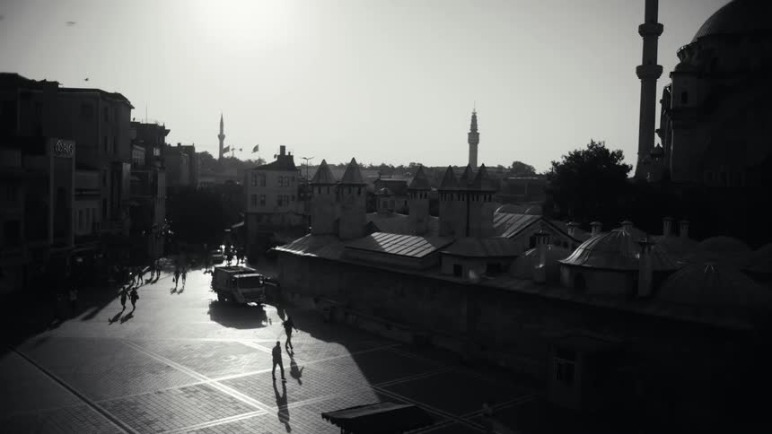 Landscape of people and vehicles moving on a city street at midday
