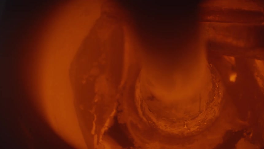 Glowing embers in orange tones inside a heated container
