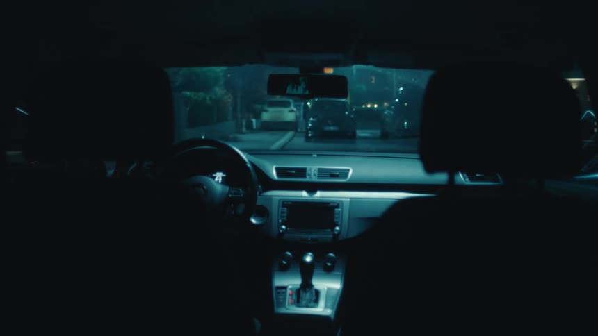 Two people sitting in the front seats getting out of a vehicle at night