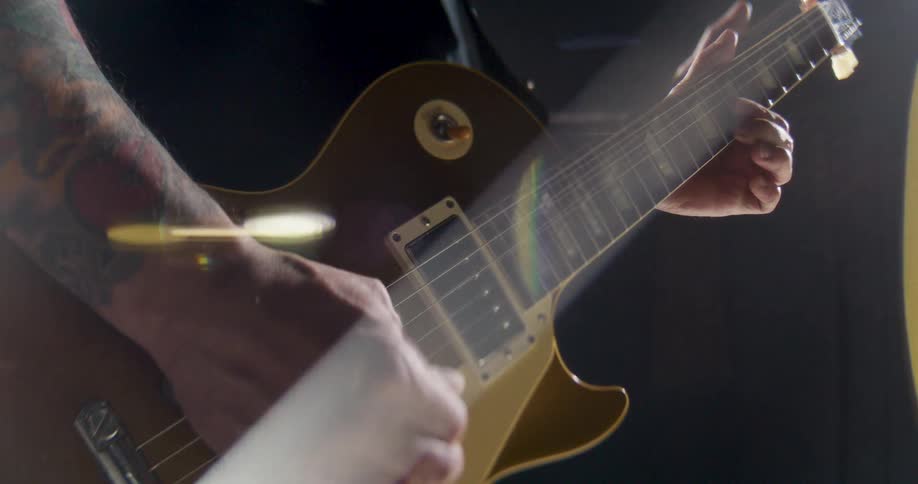 Man standing as he plays his electric guitar