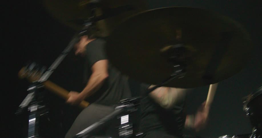 Two people playing bass and drums on a stage