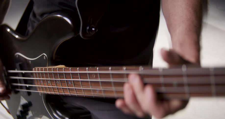 Musicians hand playing an electric bass in closeup