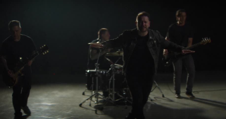 A band is playing under a spotlight on a stage