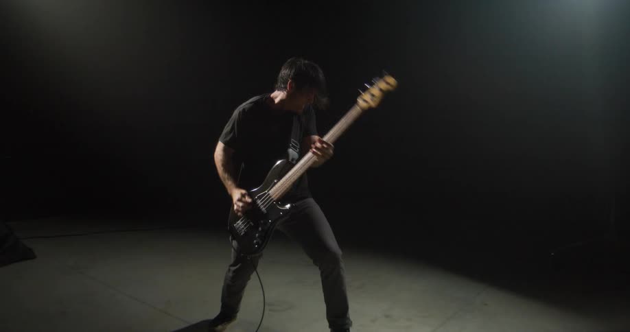 Male guitarist energetically plays an electric guitar