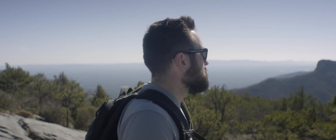 A man looks out over the horizon on the mountain