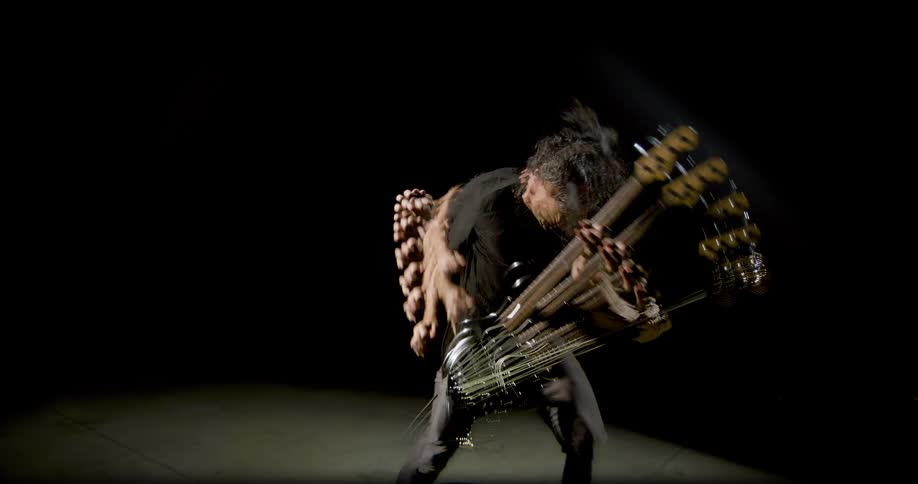 The man swings his guitar as he plays