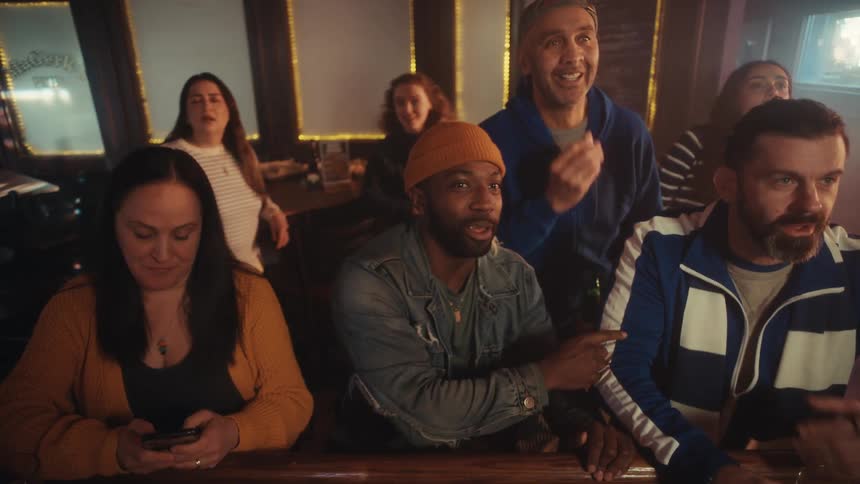 Customers in the bar talk and smile