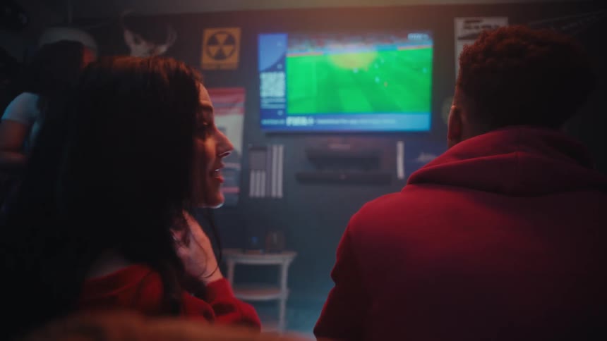 People talk and smile while watching the game at a party