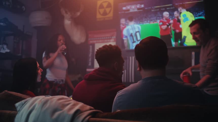 People sitting in a bar watching a sports game on television