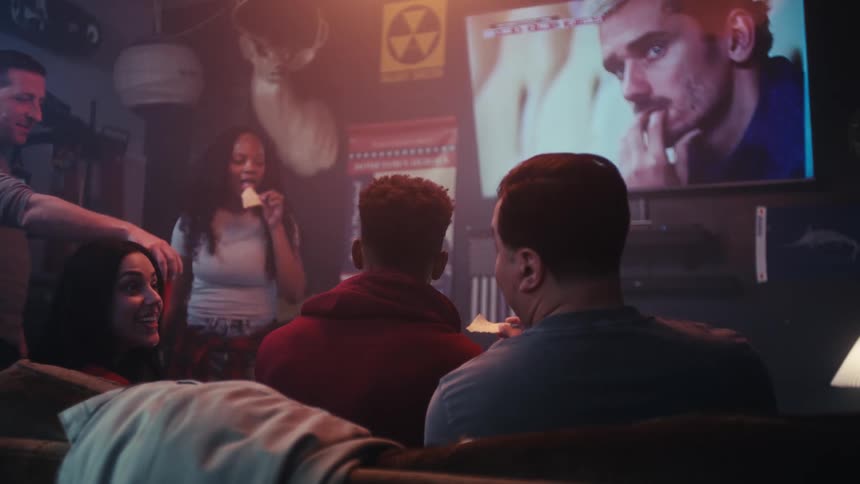 People sitting in a bar watching a sports game on television