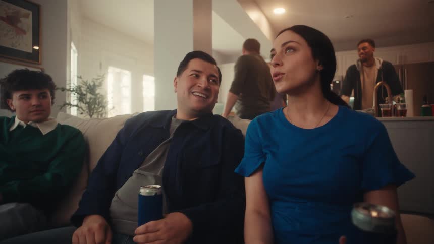 The man listens as a woman talk at a party