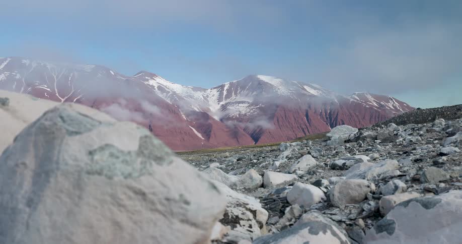The valley is covered with boulders by the mountains
