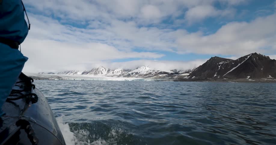 A view from a small boat of mountains in the distance