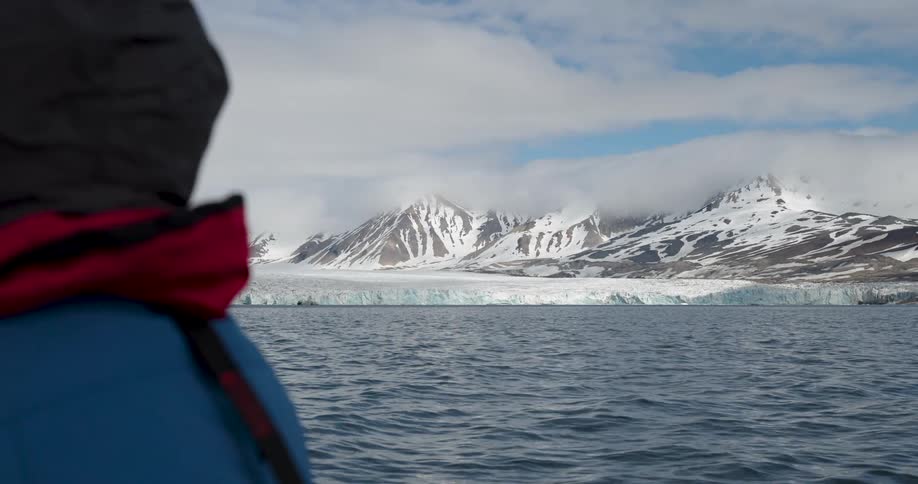 A person is looking at a glacier on the coast