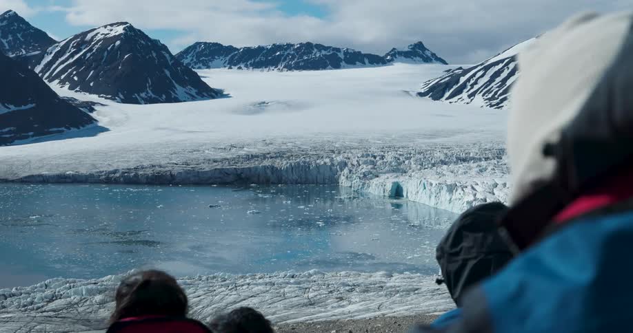 A group of people looking at icebergs and arctic ice