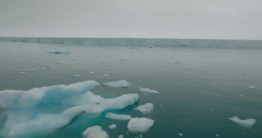 Icebergs are floating in the sea off the coast of a glacier