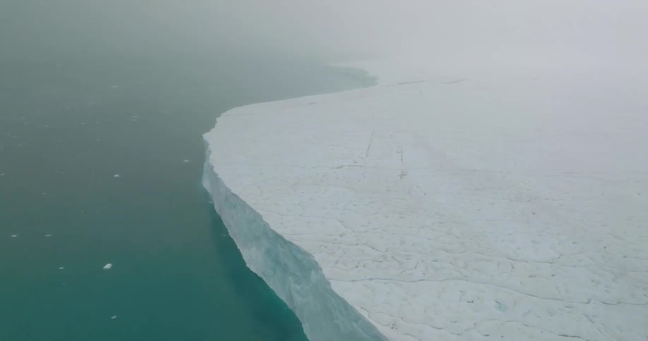 The ice covers the shore on a foggy day