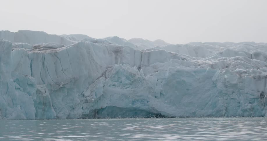 Large iceberg floating in the arctic sea at midday