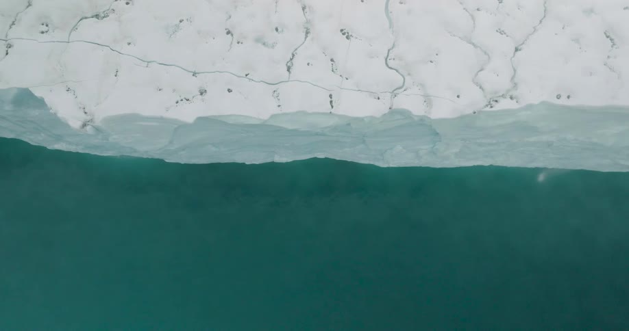 Ice shelf section with a fractured white surface and dark water below the flotation line