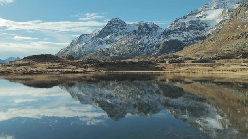 Snow on mountains along the coast reflect on the water