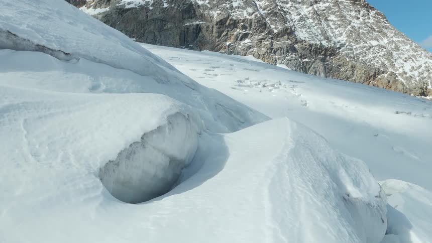 Snow covered slopes lead to a snow dusted mountains on a cloudy winter day