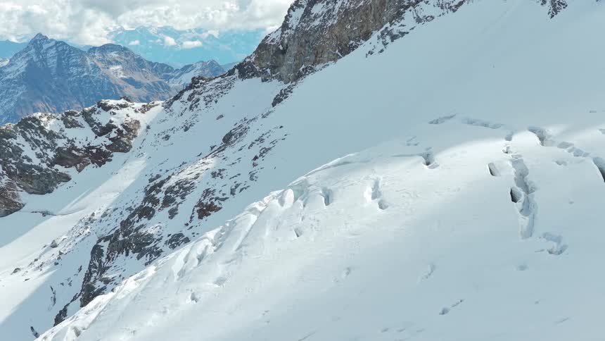 Snow covers portions of a mountain in mountainous terrain on a winter day