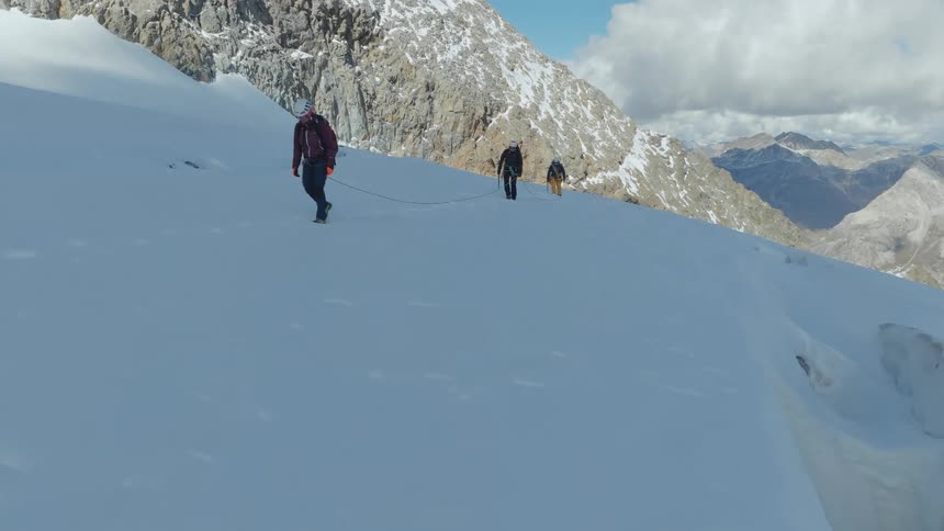 An aerial view of people hiking on a snowy mountain