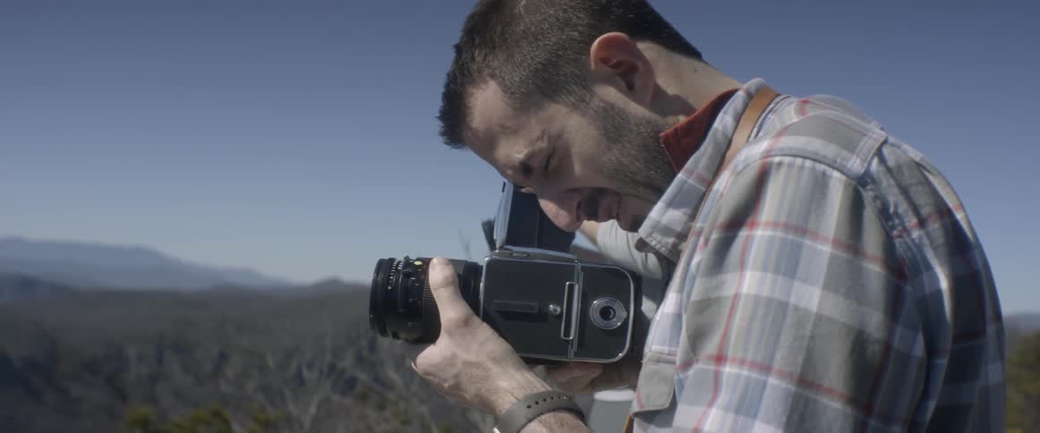 Two men use cameras to record nature