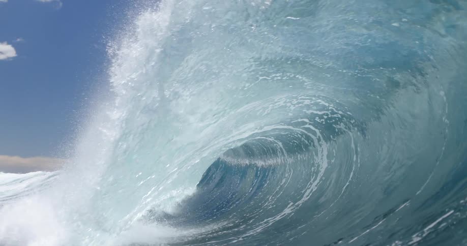 Huge wave splashes and curls and the view moves underwater