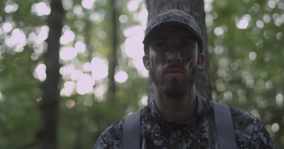A man looks around in the woods