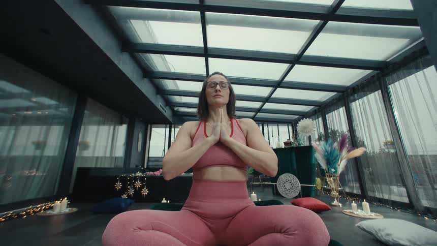 The woman is doing yoga while sitting