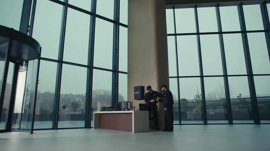 Some people coming and going from a desk in an office building
