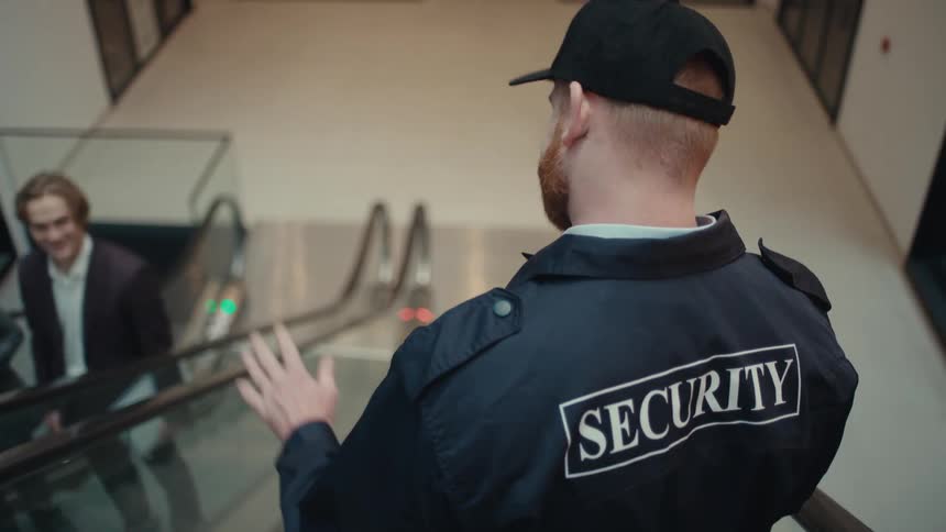 A security guard riding an escalator down