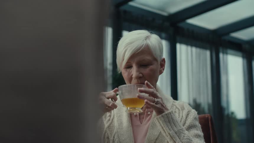 Two women drinking tea from cups in a room