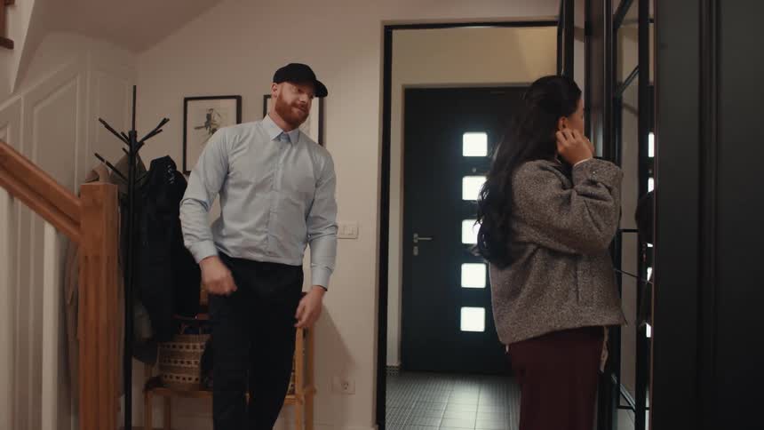 The man enters the home and kisses his wife