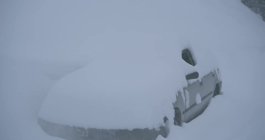 Car parked outside covered in heavy snow