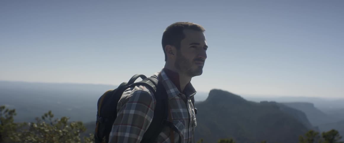 A man is hiking on a sunny day