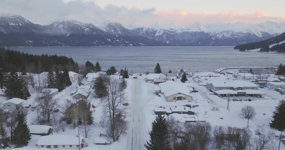 A small town is on the coast of a mountain lake in the winter